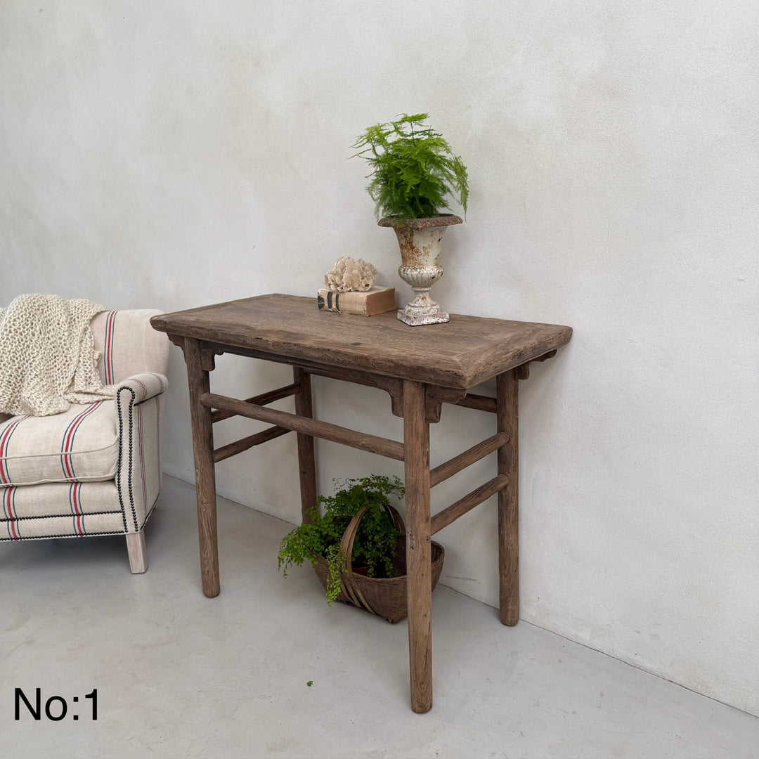 Wooden table with decorative items against a white wall