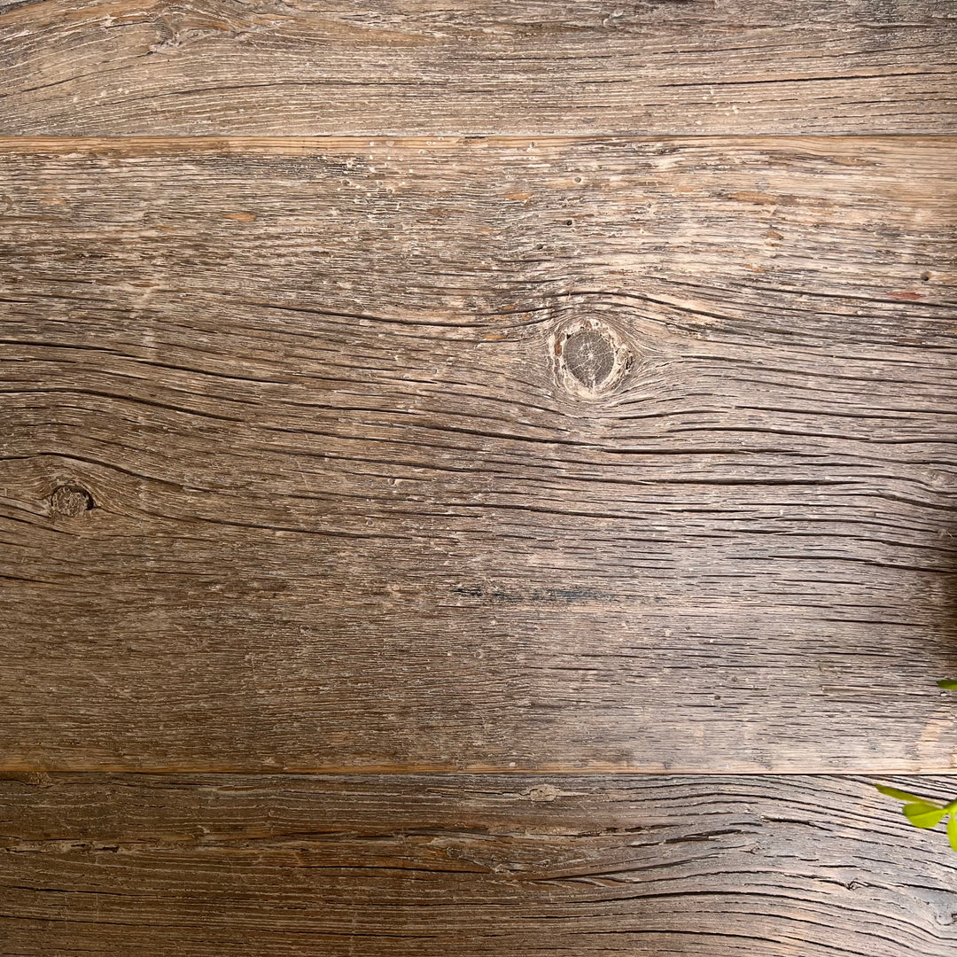 Rustic weathered wood plank texture with visible grain, knots, and horizontal seams in brown and gray tones.