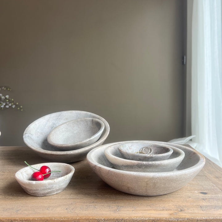 Set of stone bowls on a wooden surface with a neutral background