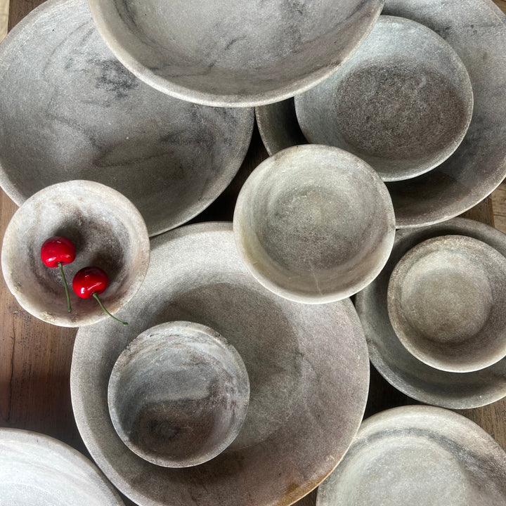 Stack of gray ceramic bowls on a wooden surface