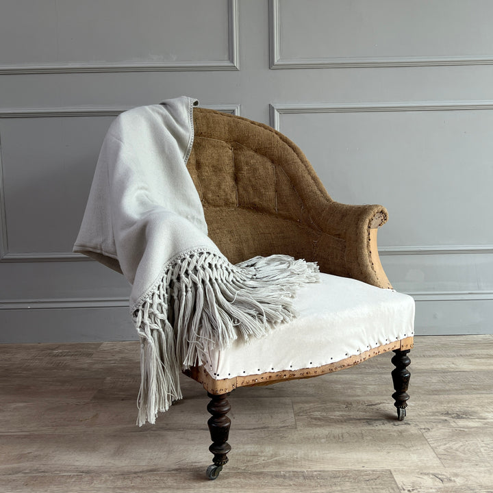 Woven Alpaca Throw Dove strewn across an armchair