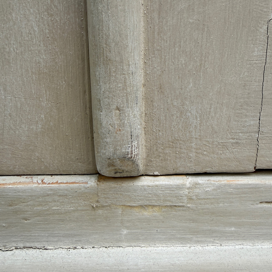 Close-up showing the softly aged painted finish of the antique French oak cabinet.
