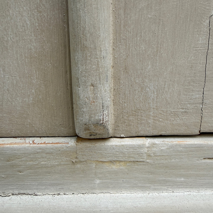 Close-up showing the softly aged painted finish of the antique French oak cabinet.
