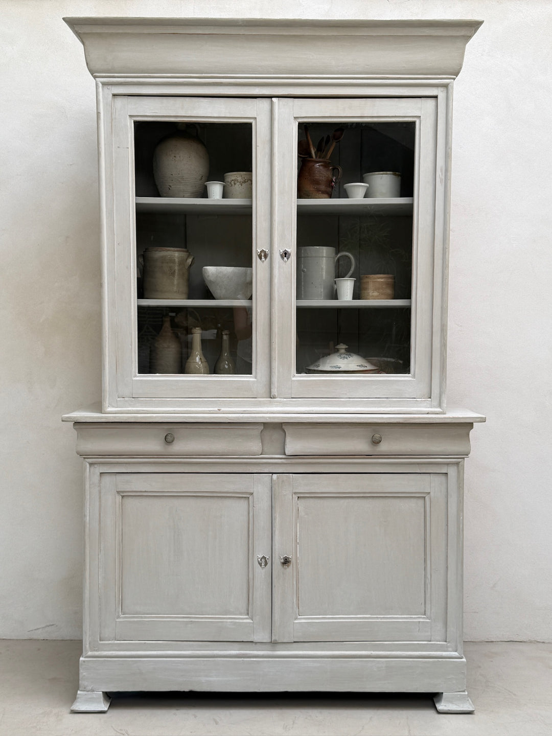 Front view of the antique French painted oak Buffet Deux Corps cabinet with glazed doors closed.
