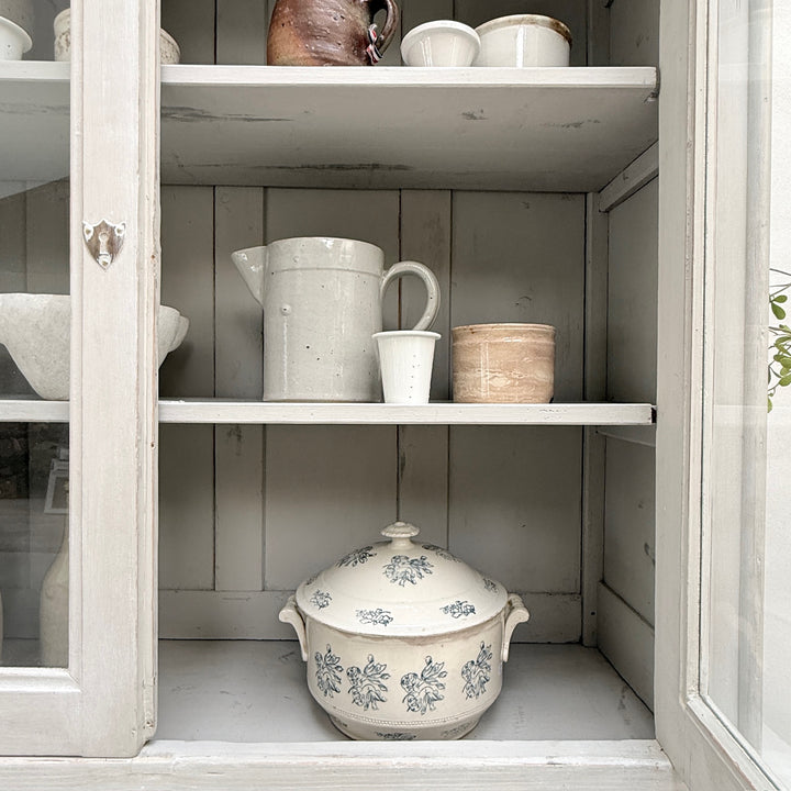 Internal display shelves inside the glazed upper section of the antique French cabinet.
