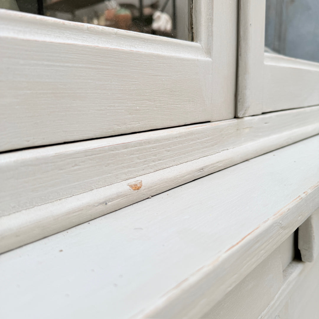 Close-up of the moulded shelf detail on the antique French painted oak cabinet.