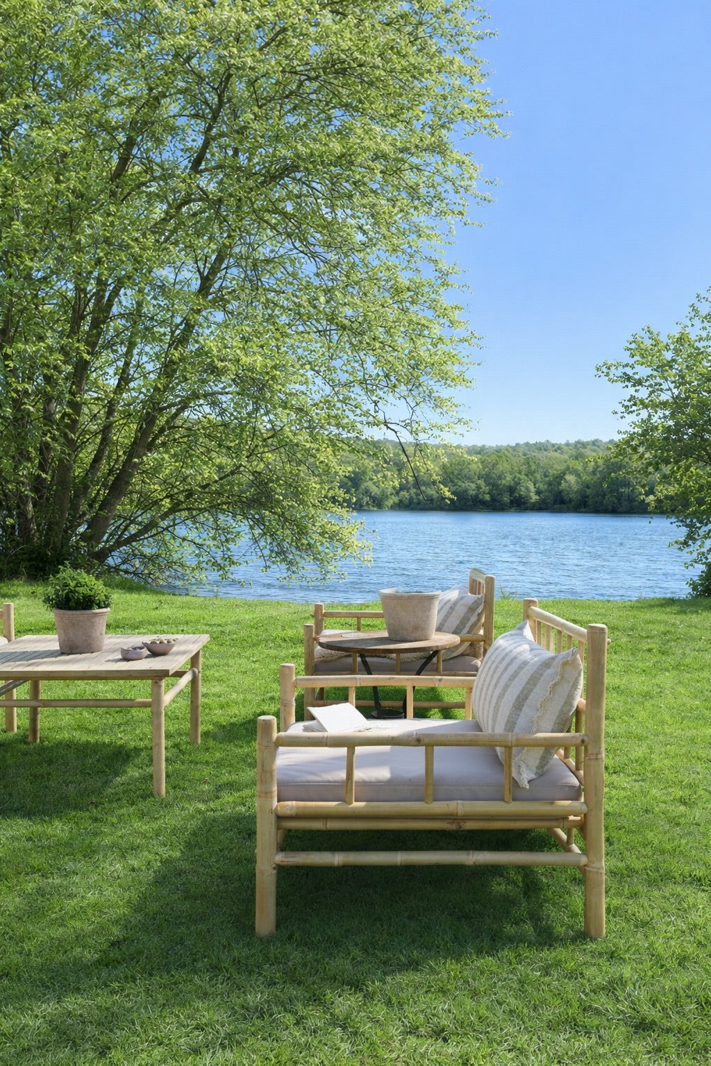 Outdoor setting with wooden furniture on a grassy area by a lake