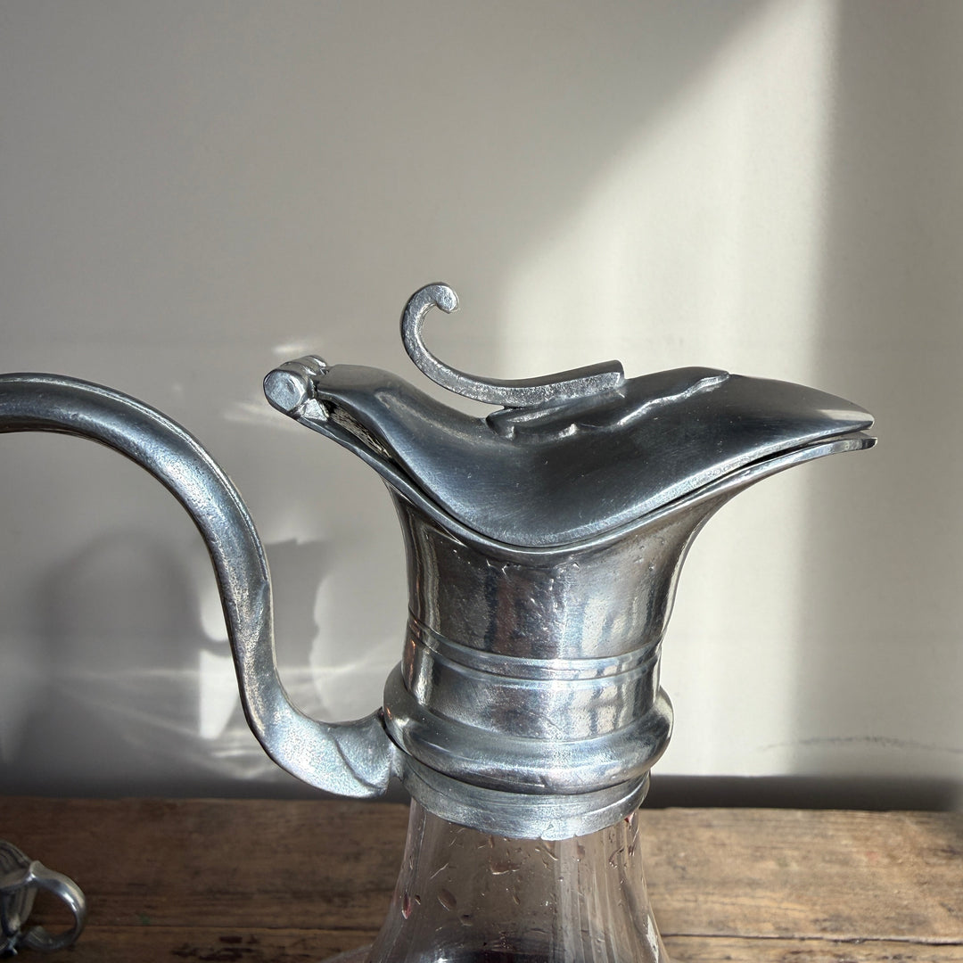 Close-up of the sculptural pewter pouring lip and traditional metal collar on a French glass wine carafe.