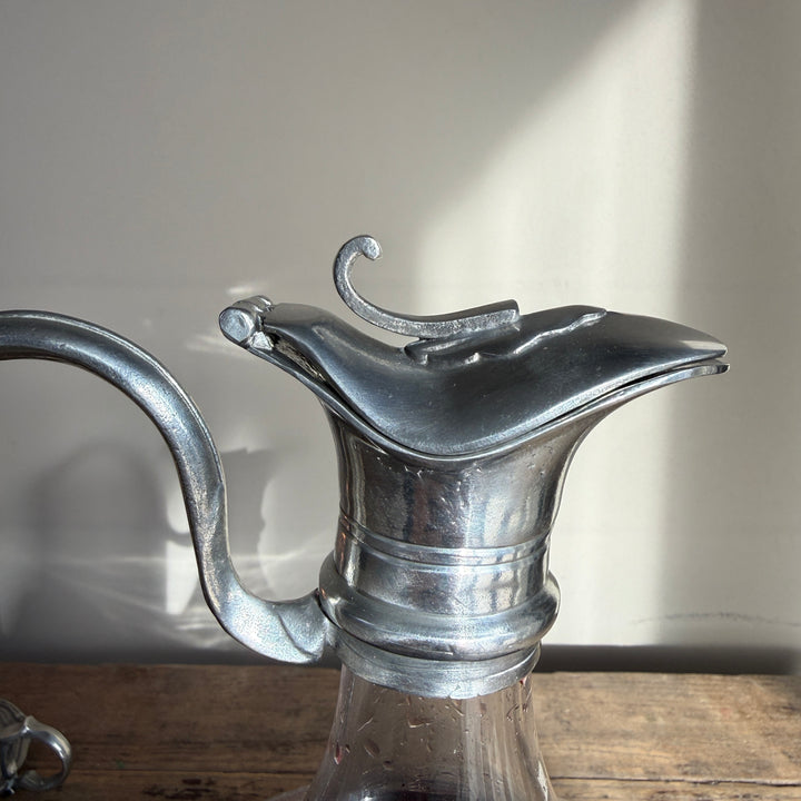 Close-up of the sculptural pewter pouring lip and traditional metal collar on a French glass wine carafe.