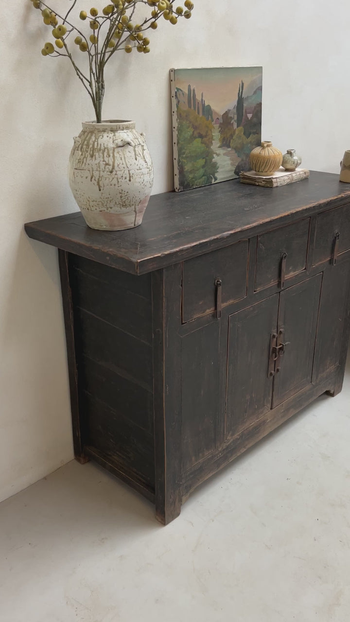 Black antique cupboard styled with vintage oil painting and antique vases.