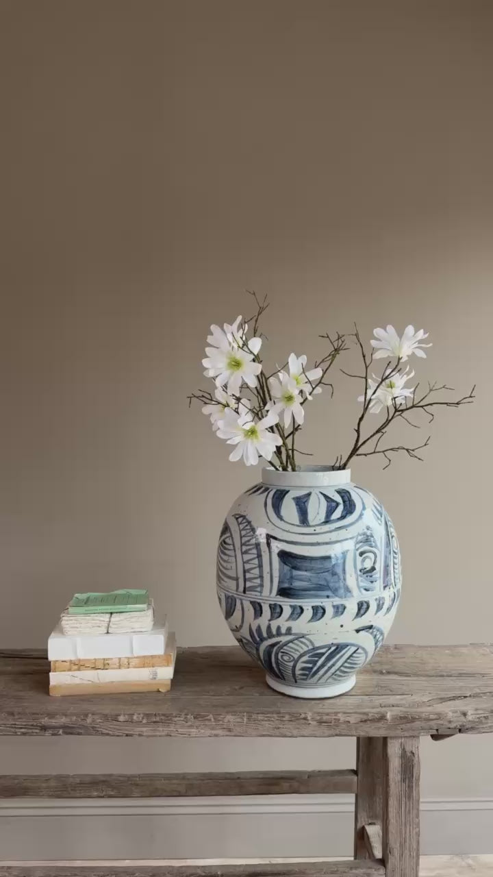 Lifestyle video of the hand-painted blue and white porcelain vase styled with blossom stems in a contemporary country interior.
