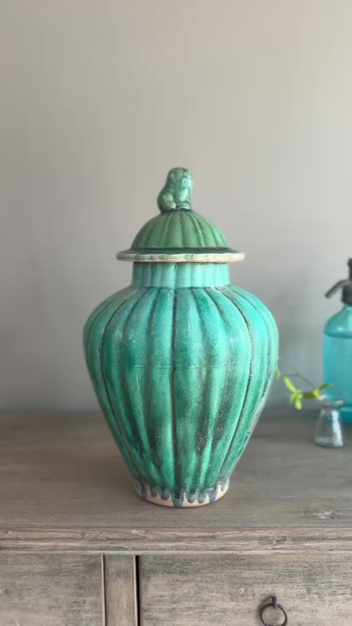 Lifestyle video of a green glazed stoneware temple jar styled in a contemporary country interior with decorative accessories.
