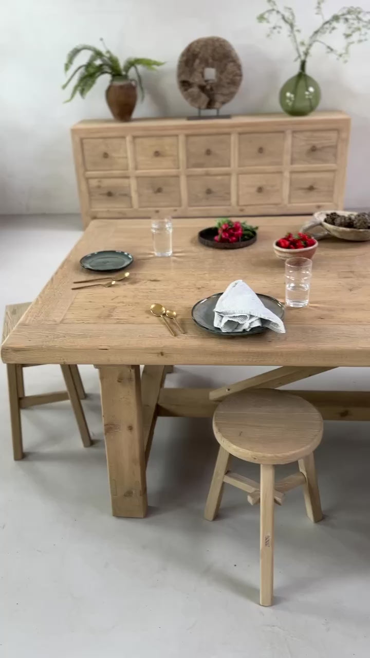 12-seater reclaimed wood dining table situated in a large open-plan living room.