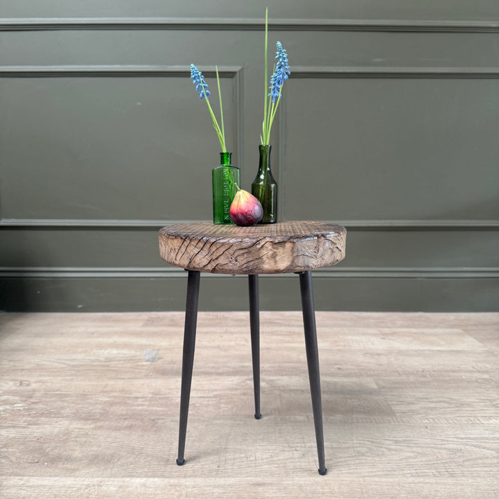 Small rustic elm side table with a solid elm round top and black cast iron hairpin legs.